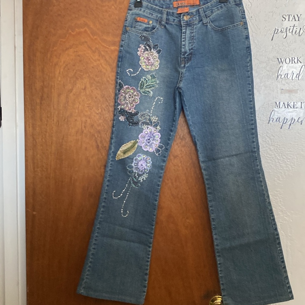 Floral beaded boot cut blue jeans by Daniel. Size 8. Never been worn.